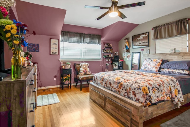 bedroom featuring multiple windows, light wood-type flooring, vaulted ceiling, and ceiling fan