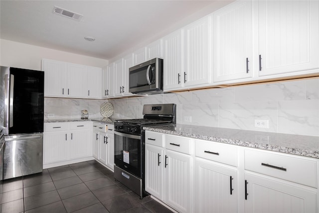 kitchen featuring appliances with stainless steel finishes, white cabinets, and backsplash