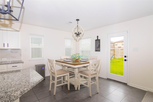 dining space featuring a chandelier and dark tile patterned flooring