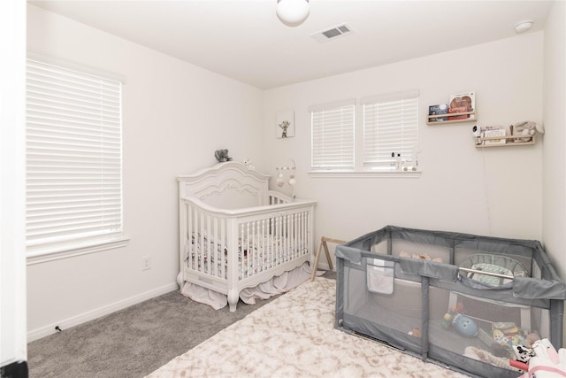 bedroom with a crib and carpet