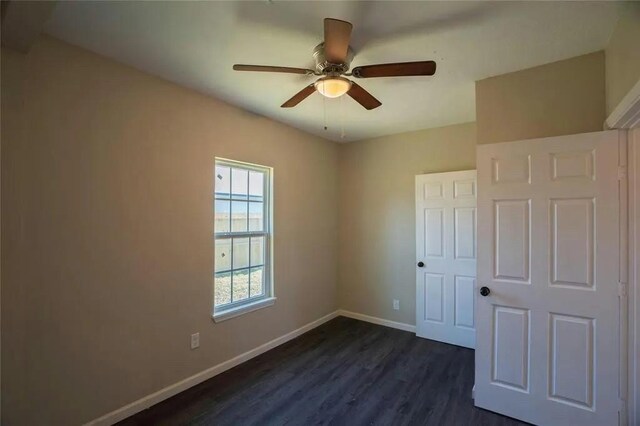 spare room with ceiling fan and dark wood-type flooring