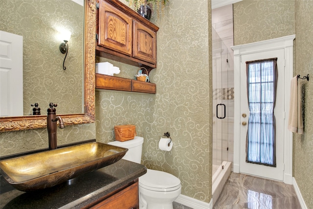 bathroom with vanity, a shower with shower door, and toilet