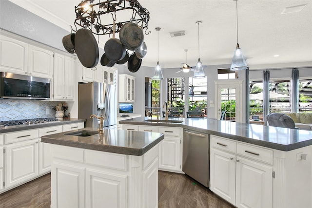 kitchen with white cabinets, sink, a kitchen island with sink, and appliances with stainless steel finishes