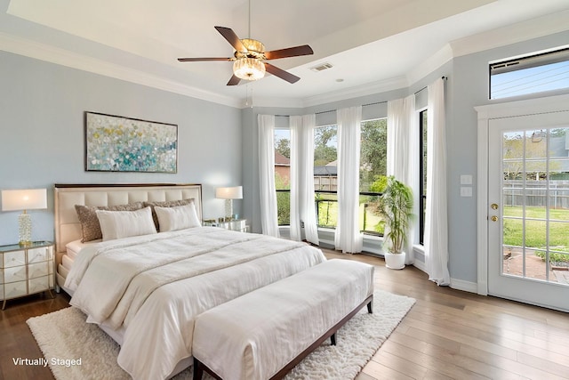 bedroom featuring hardwood / wood-style floors, ceiling fan, ornamental molding, and access to outside