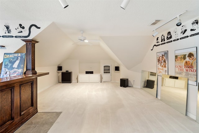 bonus room featuring ceiling fan, light colored carpet, a textured ceiling, and vaulted ceiling