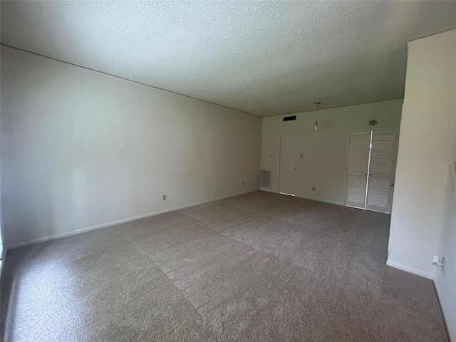 spare room with carpet and a textured ceiling