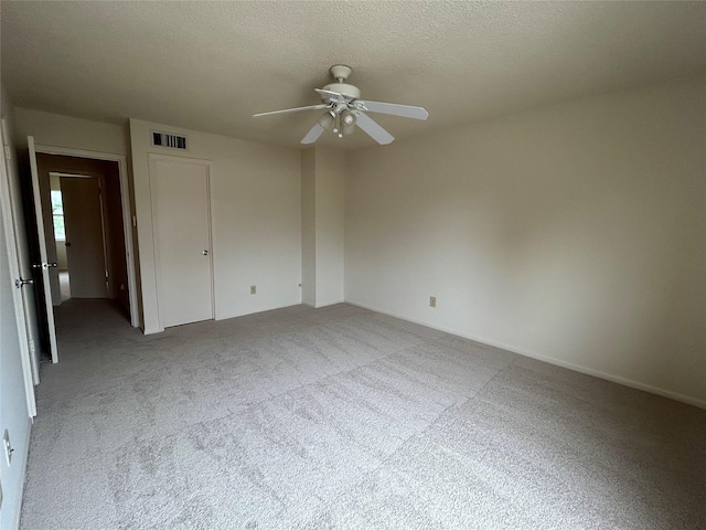 unfurnished bedroom with carpet flooring, ceiling fan, and a textured ceiling