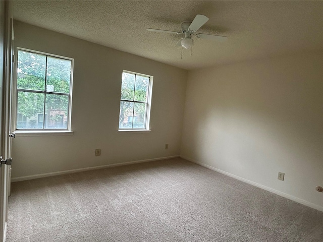 carpeted spare room with a textured ceiling and ceiling fan