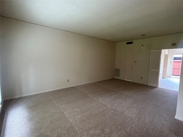 empty room with light carpet and a textured ceiling