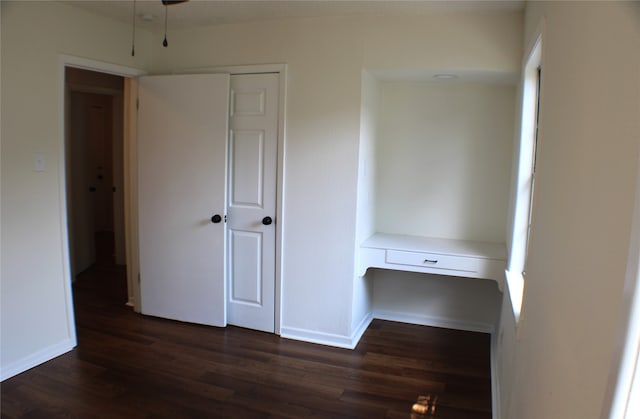 unfurnished bedroom with dark hardwood / wood-style floors and a closet