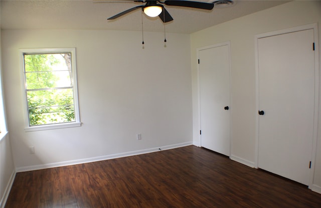 unfurnished room with ceiling fan and dark hardwood / wood-style flooring