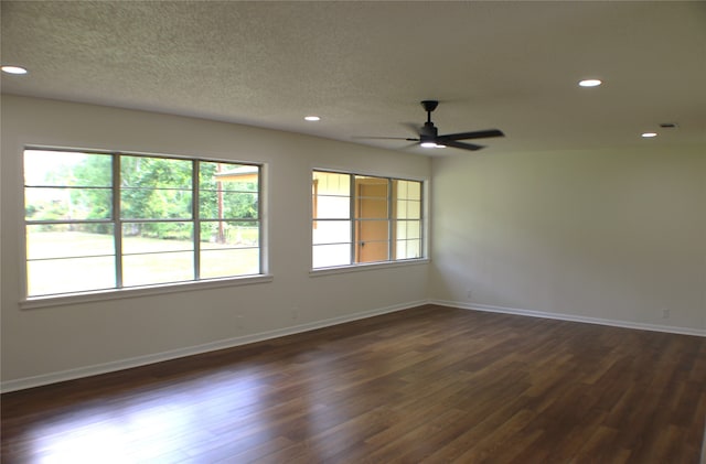 spare room with a healthy amount of sunlight, dark hardwood / wood-style floors, and ceiling fan