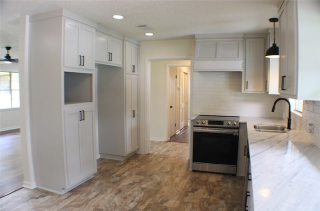 kitchen featuring decorative light fixtures, backsplash, hardwood / wood-style floors, sink, and electric stove