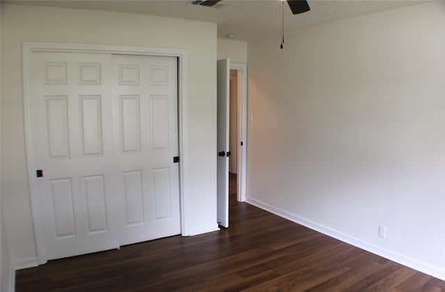 unfurnished bedroom featuring a textured ceiling, dark wood-type flooring, a closet, and ceiling fan