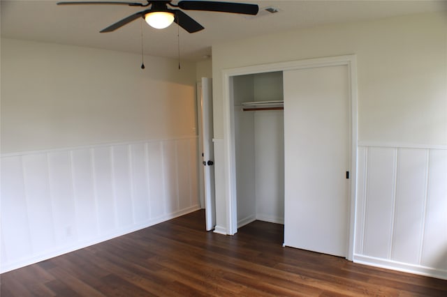 unfurnished bedroom with dark wood-type flooring, a closet, and ceiling fan