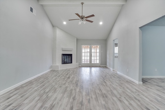 unfurnished living room featuring french doors, a brick fireplace, high vaulted ceiling, light hardwood / wood-style floors, and ceiling fan