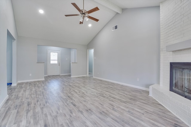 unfurnished living room with beamed ceiling, light wood-type flooring, a fireplace, high vaulted ceiling, and ceiling fan