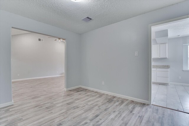 6218 Sunnygate Dr, Spring, TX 77373 - empty room with ceiling fan, light wood finished floors, visible vents, and a textured ceiling