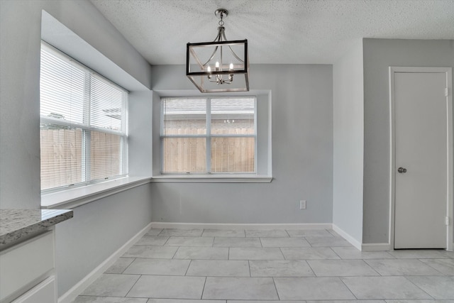 6218 Sunnygate Dr, Spring, TX 77373 - unfurnished dining area with a textured ceiling, baseboards, and a notable chandelier