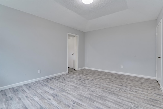 empty room featuring a textured ceiling and light wood-type flooring