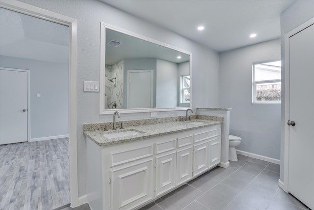 bathroom featuring vanity, tile patterned floors, toilet, and walk in shower