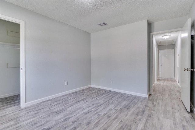 6218 Sunnygate Dr, Spring, TX 77373 - unfurnished bedroom featuring baseboards, light wood-style floors, attic access, and a textured ceiling