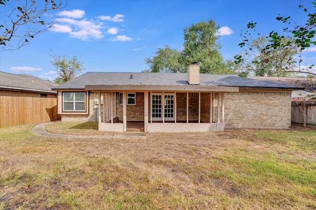 6218 Sunnygate Dr, Spring, TX 77373 - back of house featuring french doors, a yard, a chimney, a fenced backyard, and brick siding