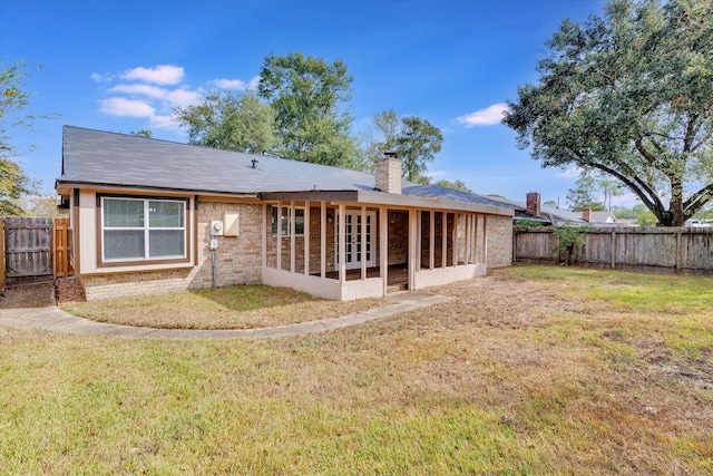 rear view of property with a yard