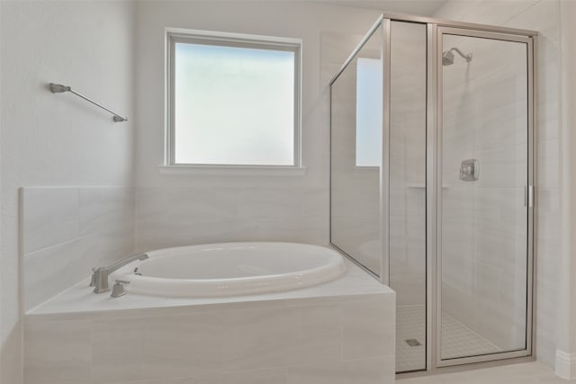 bathroom featuring separate shower and tub