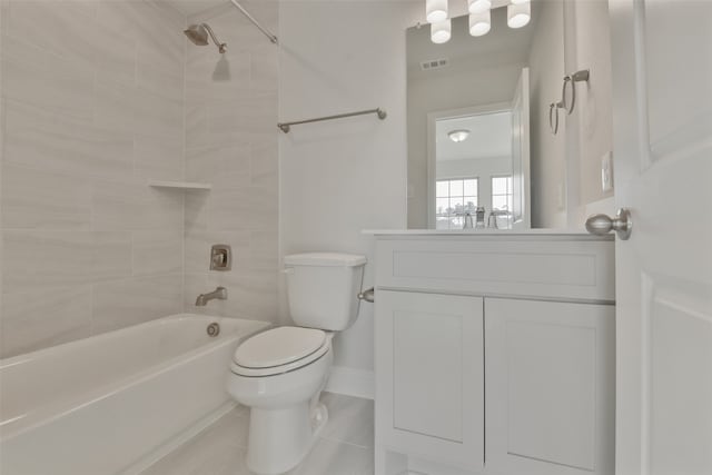 full bathroom featuring tile patterned flooring, tiled shower / bath, vanity, and toilet