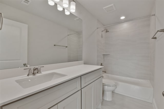 full bathroom with tiled shower / bath, vanity, and toilet