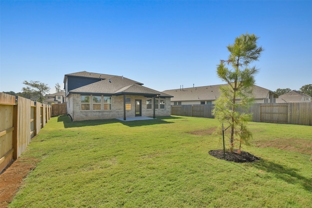 back of property with a yard and a patio