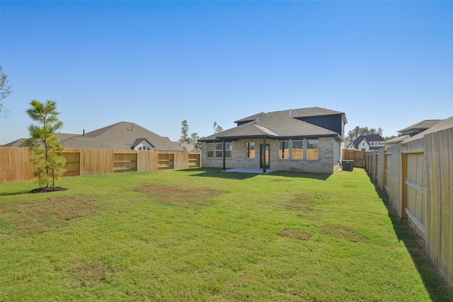 back of property featuring a lawn and central AC