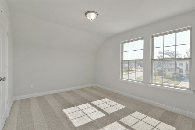 additional living space with light colored carpet and lofted ceiling