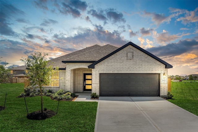 view of front of house featuring a garage and a yard