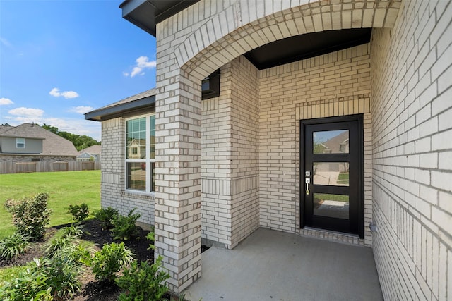 view of exterior entry featuring a yard