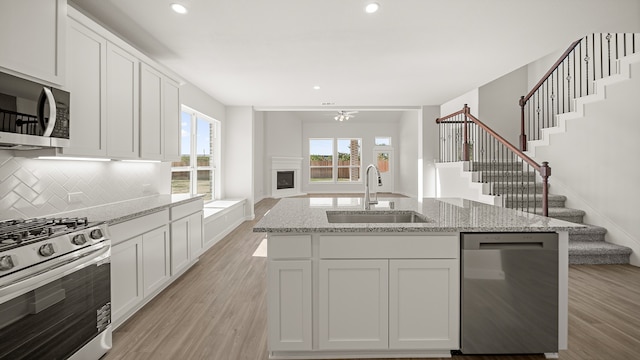 kitchen featuring sink, white cabinets, stainless steel appliances, and light hardwood / wood-style floors