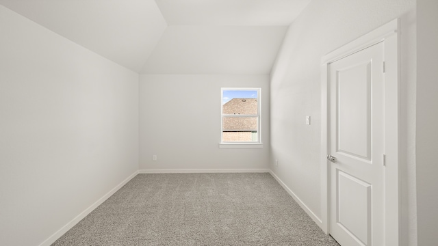 additional living space with carpet floors and vaulted ceiling