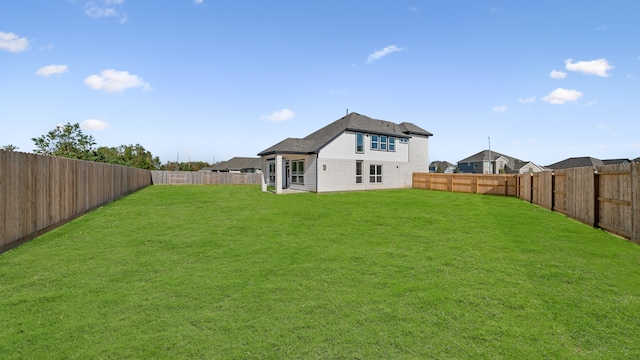 rear view of property with a yard