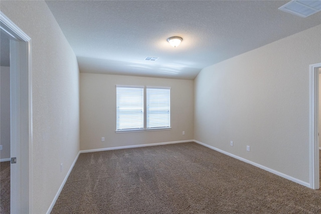 carpeted empty room with a textured ceiling and lofted ceiling