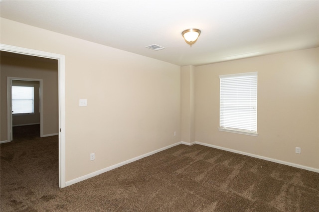 unfurnished room with dark colored carpet