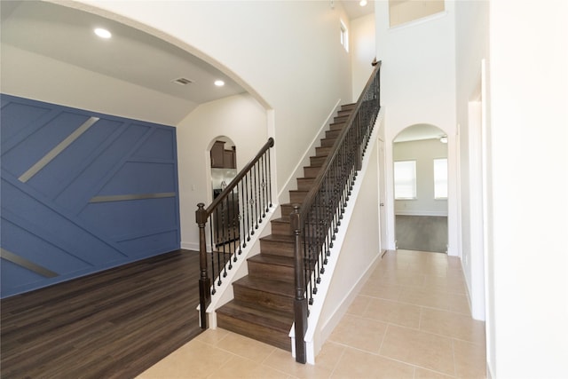 staircase featuring vaulted ceiling and tile patterned floors