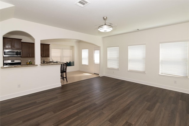 unfurnished living room featuring lofted ceiling, ceiling fan, and dark hardwood / wood-style floors