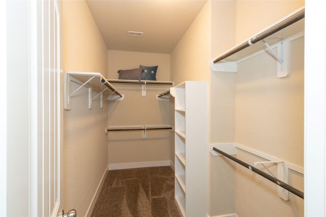 walk in closet featuring dark colored carpet