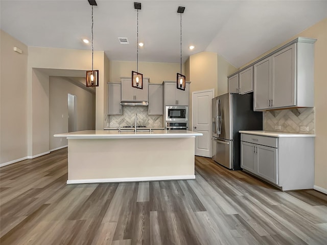 kitchen featuring tasteful backsplash, gray cabinets, hanging light fixtures, and stainless steel appliances