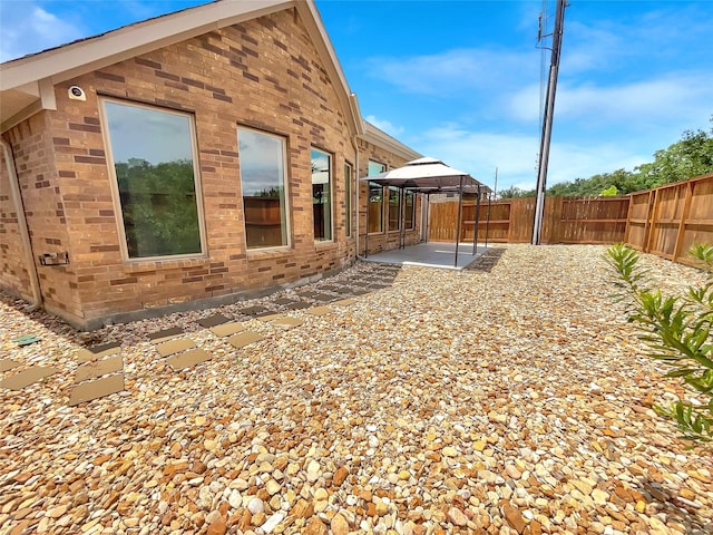 view of side of home with a gazebo and a patio