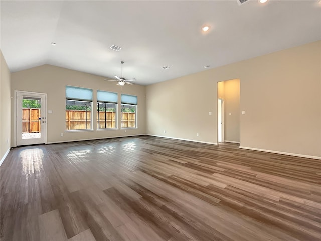 empty room featuring dark hardwood / wood-style floors, vaulted ceiling, and ceiling fan