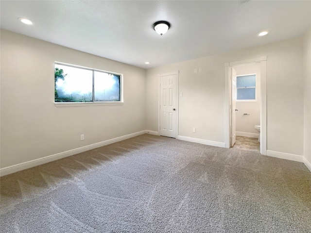 unfurnished bedroom with connected bathroom and carpet