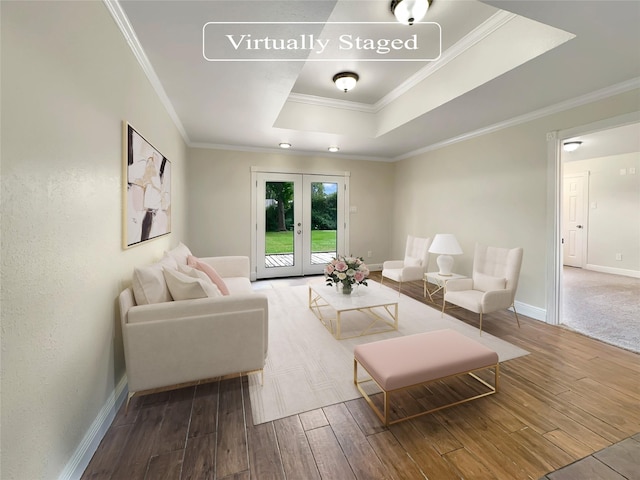 living room with a raised ceiling, ornamental molding, hardwood / wood-style flooring, and french doors