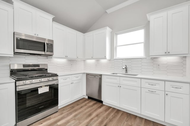 kitchen featuring sink, white cabinetry, stainless steel appliances, and tasteful backsplash